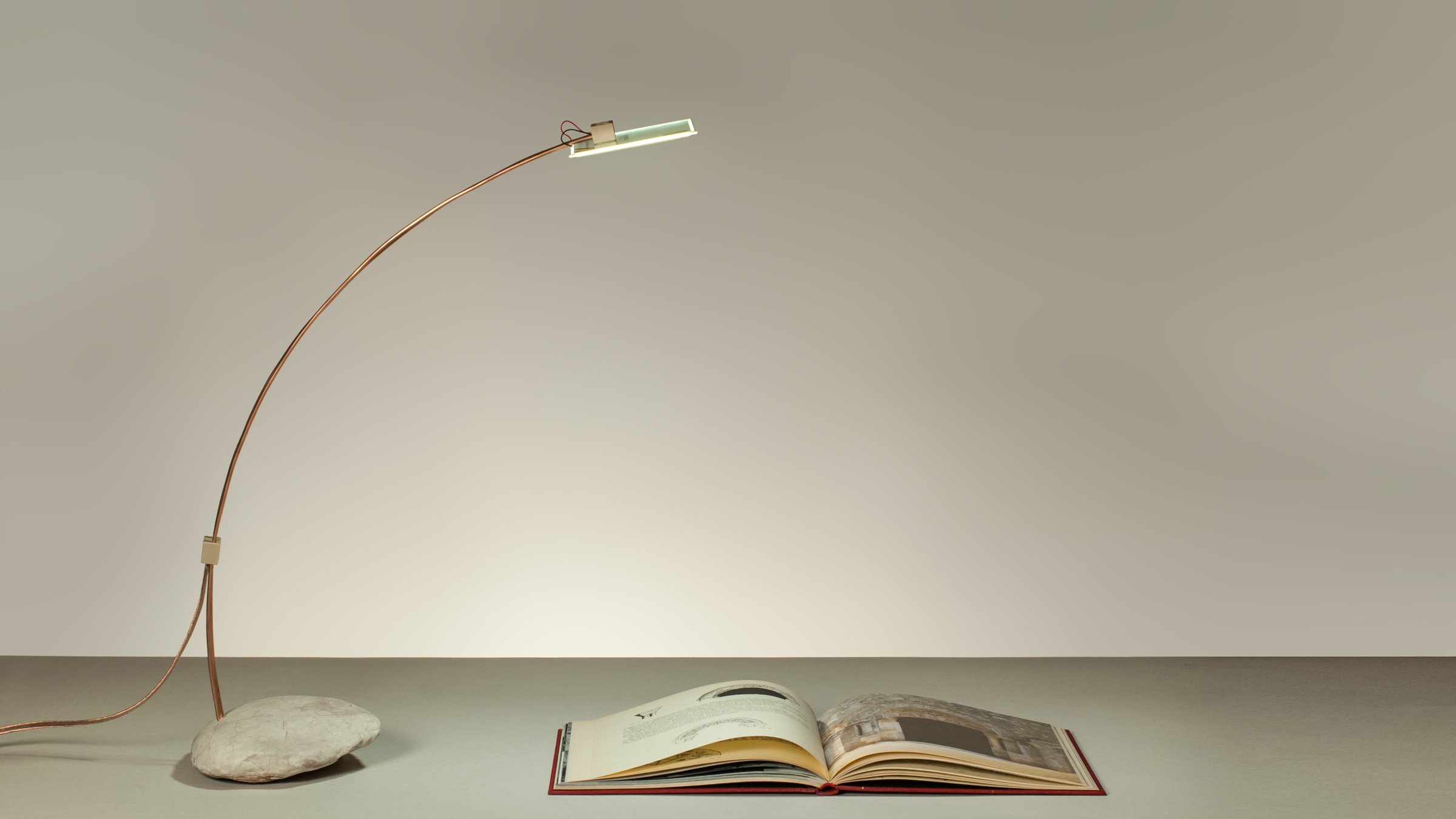 Cruda, OLED table lamp in contrast with a stone
