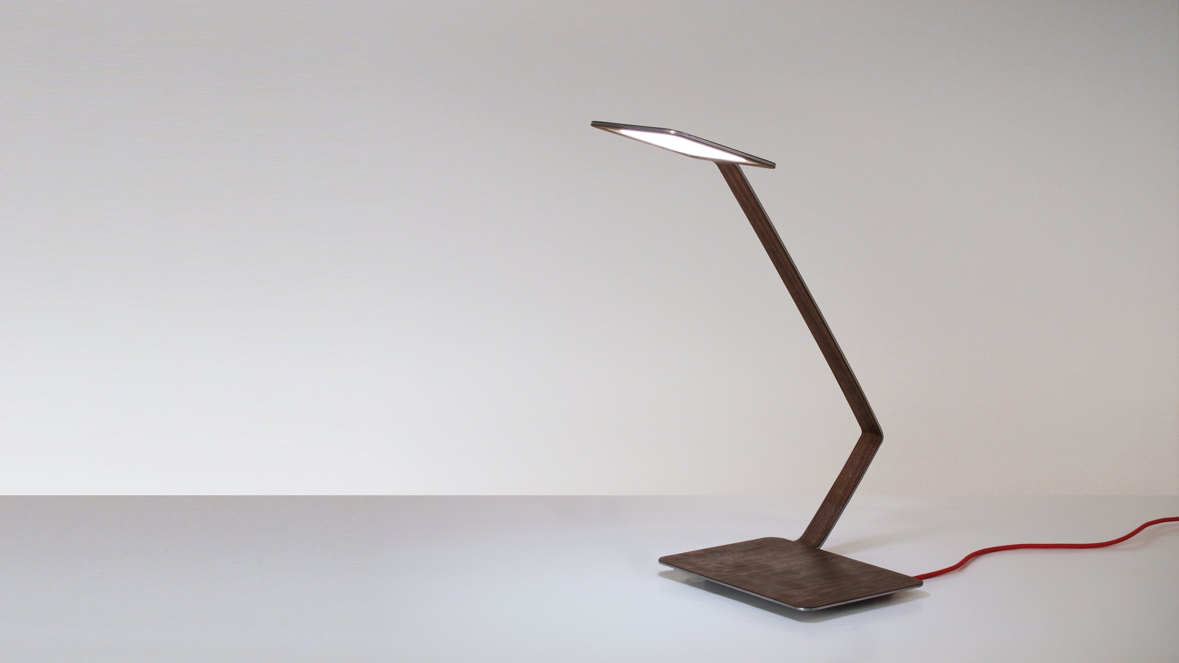 Lanx switched on, with the OLED light filtering through the walnut wood
