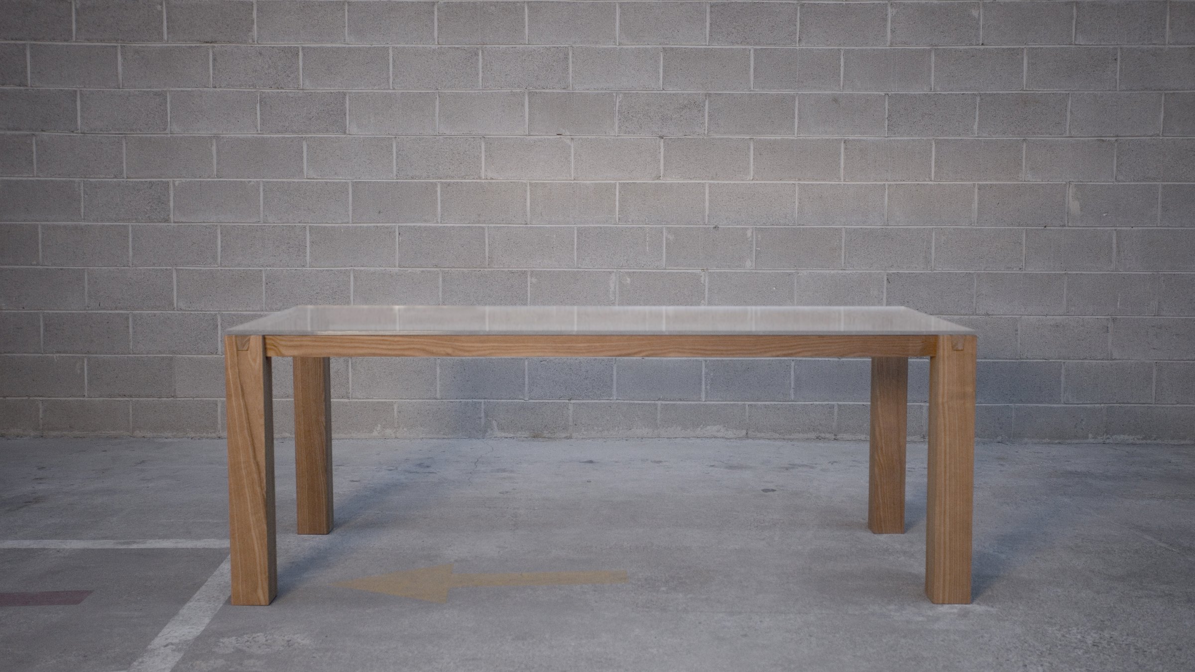 Travi, knock-down table in solid wood with a glass top